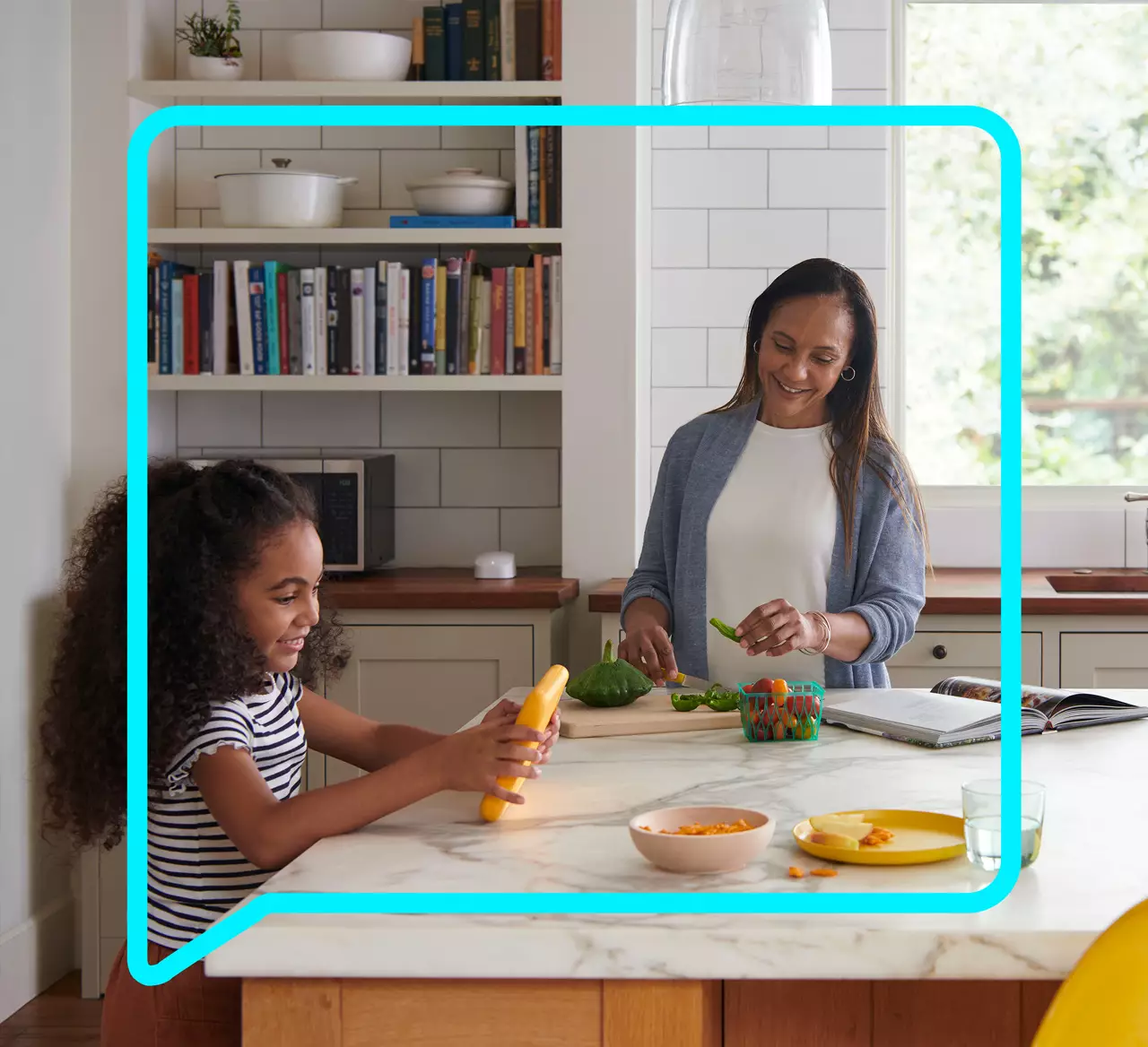 child using her tablet in the kitchen while her parents make a meal