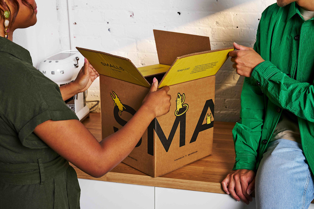 A box of Smalls is opened on the counter by two people