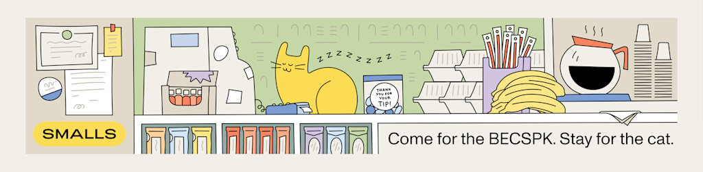 A cat sits on the counter at a bodega in NYC surrounded by coffee, a cash register, tip jars, bananas, and more.