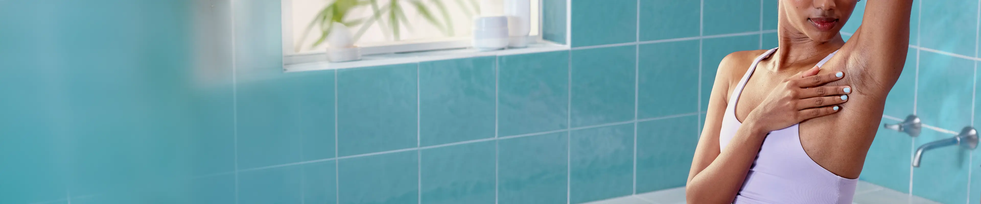 Mujer afeitándose las axilas en el baño