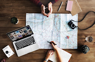 Two people mapping out a route Table with map and laptop