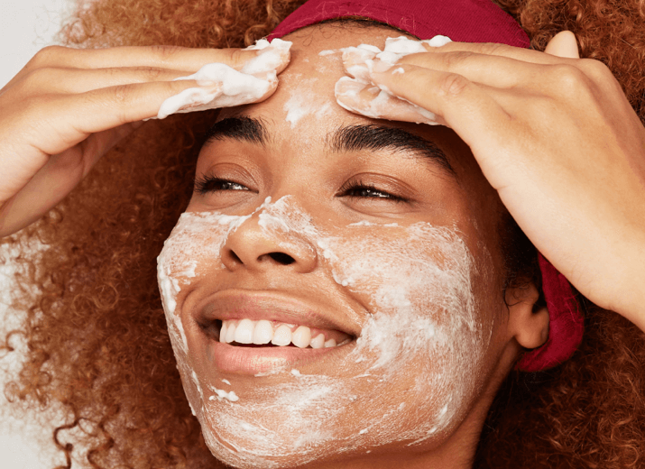 Picture of a young, smiling woman applying a face mask Health and Beauty industry page - 2020 Consumer report