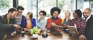 People sitting at table with tablets and devices people-at-table-with-tablets-and-devices