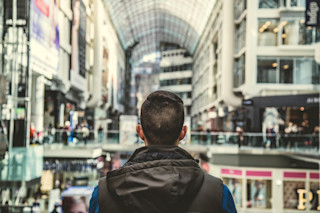 Man looking out at mall Why do people write reviews?