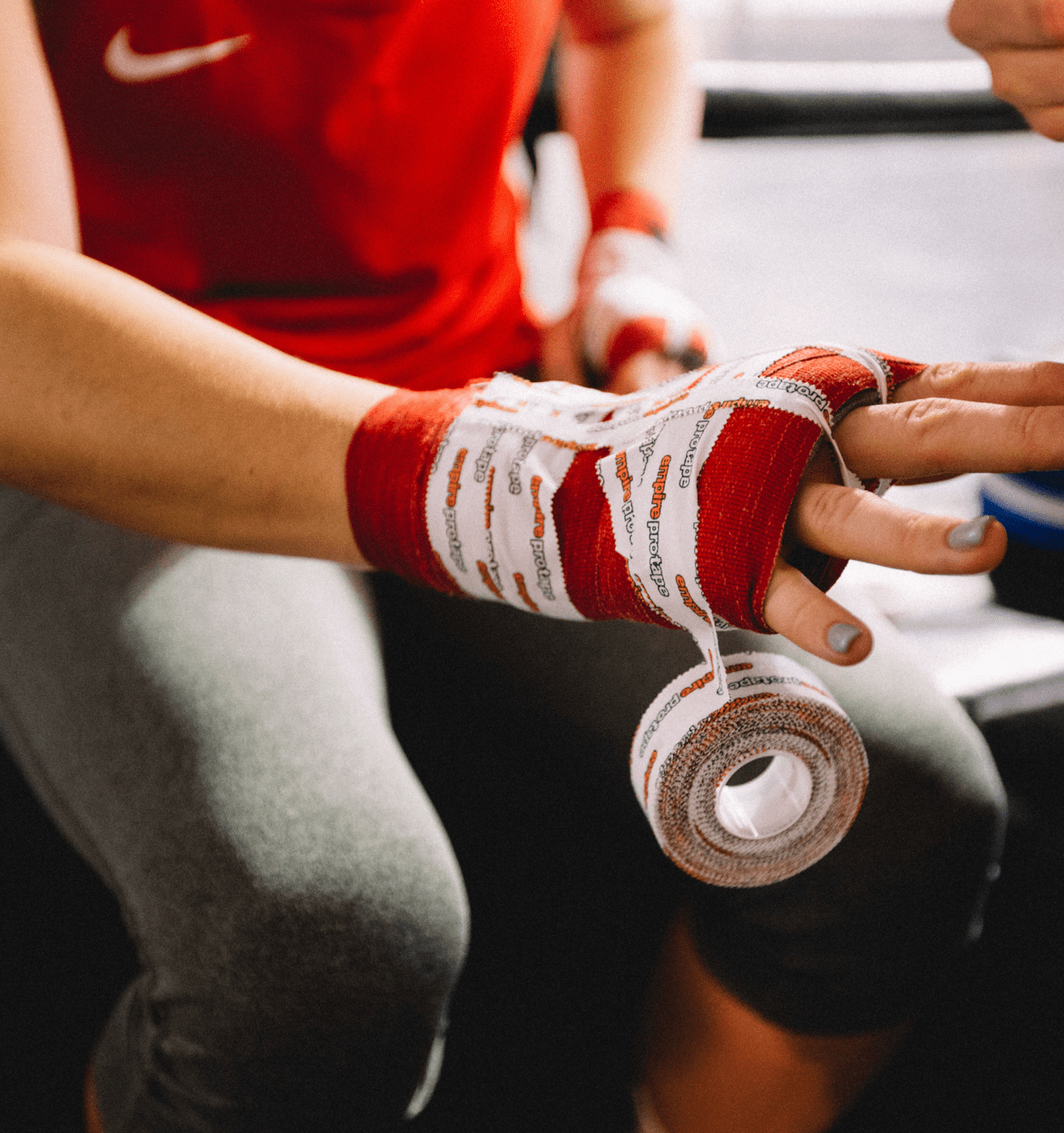 Photo of a sports person wrapping their hands with sports tape. Features - Product Reviews - Rumble Store main image