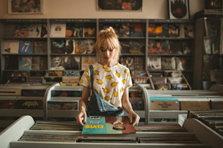 Fashionable woman shopping for vinyl records in a store Woman in Vinyl Store