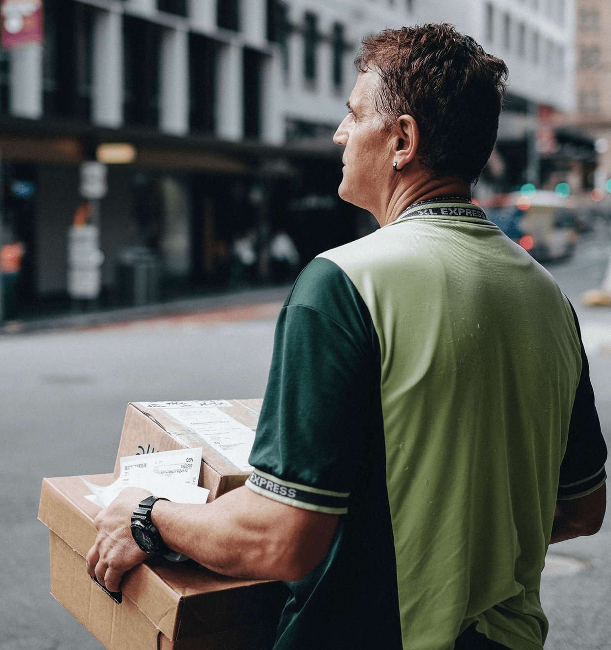 Photo of a delivery man carrying two packages uShip's promo photo of a delivery man