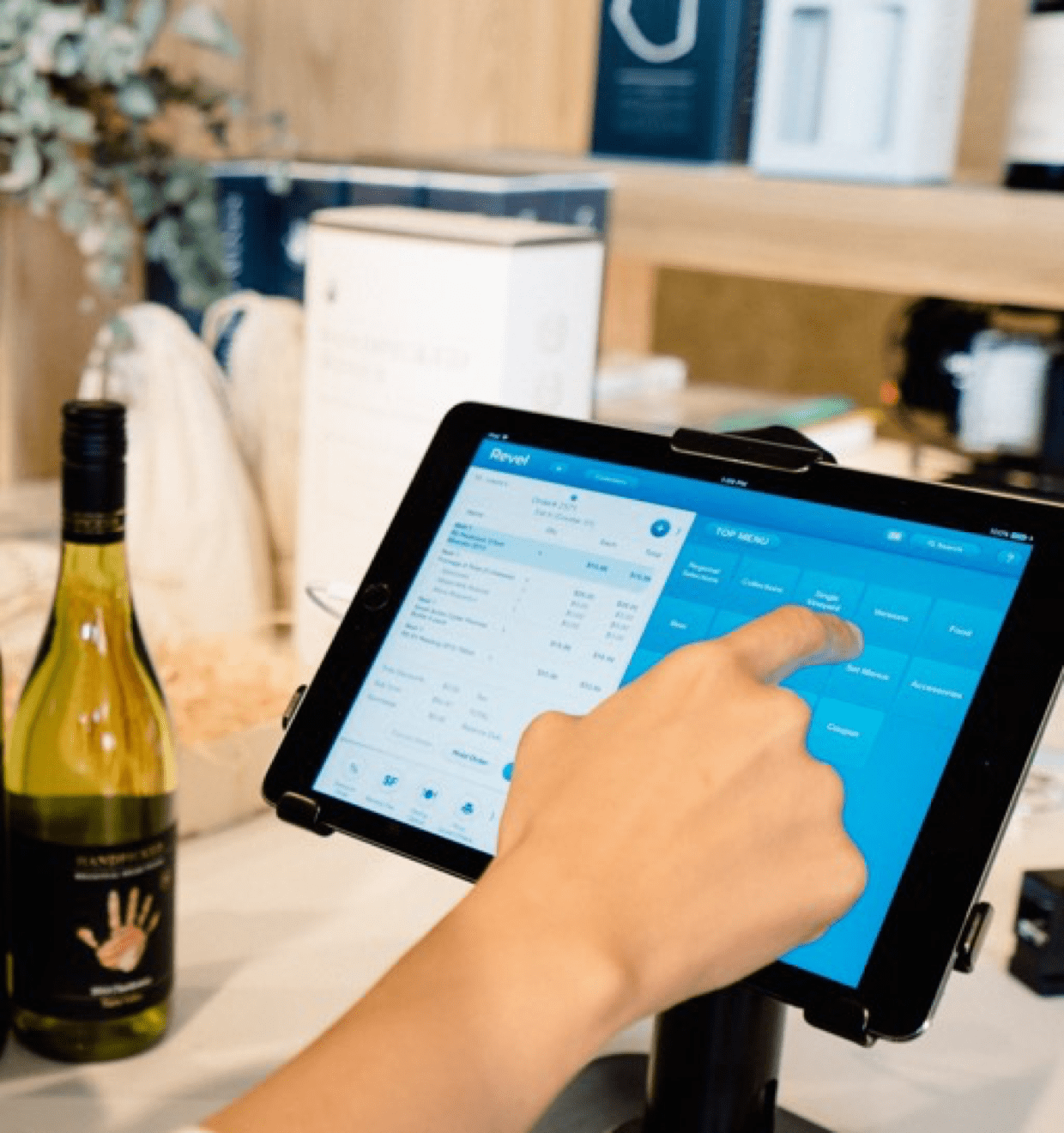 Photo of a person interacting with the Revel Systems interface on a tablet Revel Systems promo photo of a tablet