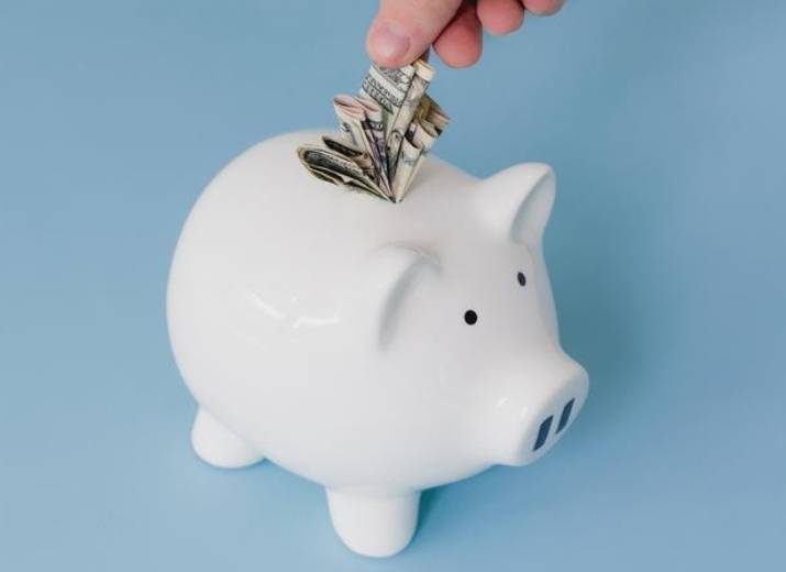 Image of someone putting money into a piggy bank Finance industry page - Building trust in financial services report - Image