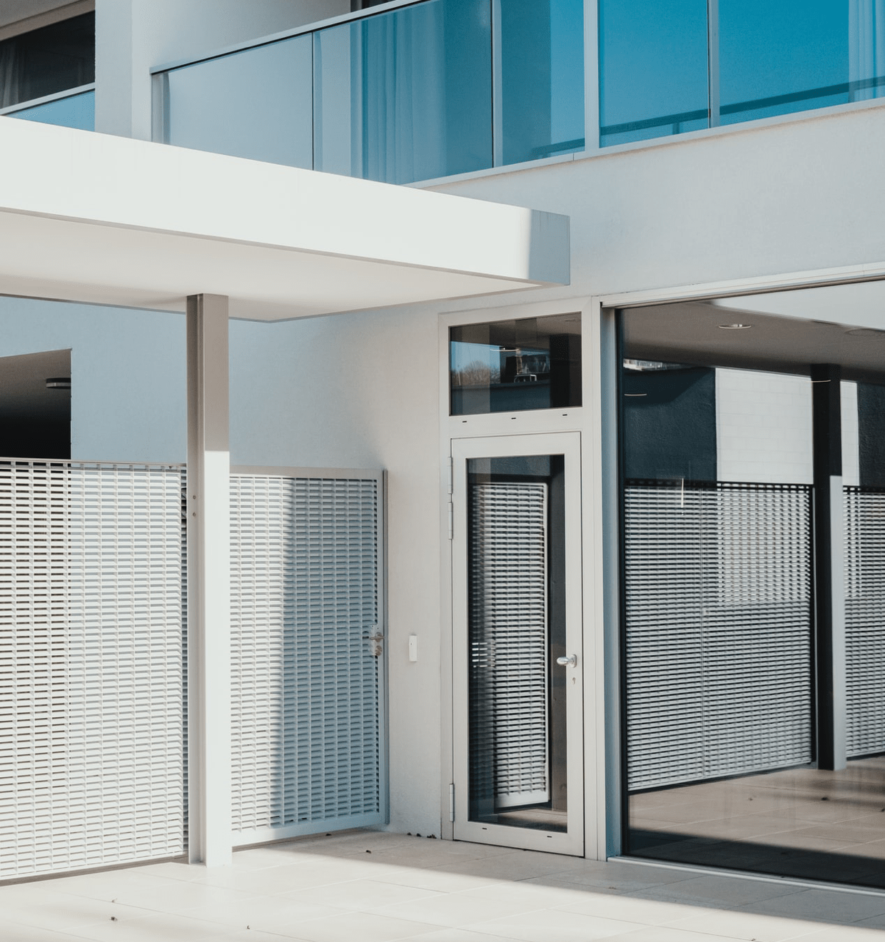 Entrance to a modern square house with white walls Vivint promo image of a modern building