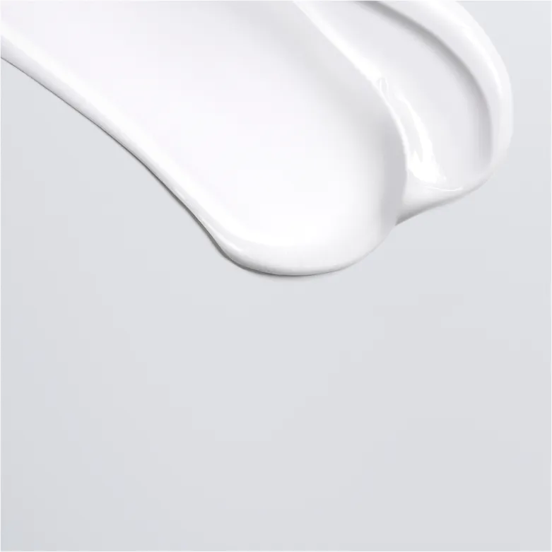 A swirl of thick, white moisturizing cream or lotion against a light gray background, showcasing a smooth texture.