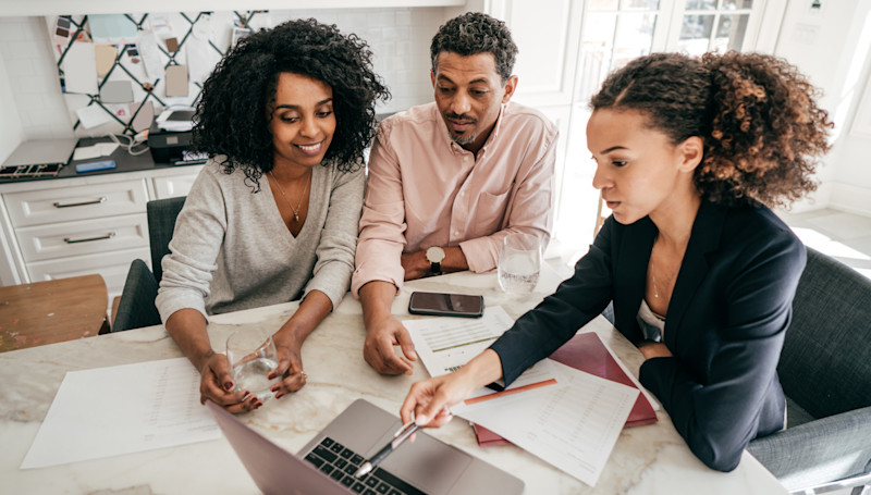 couple looking at paperwork with an adviser