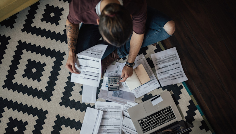man looking at calculator and paperwork