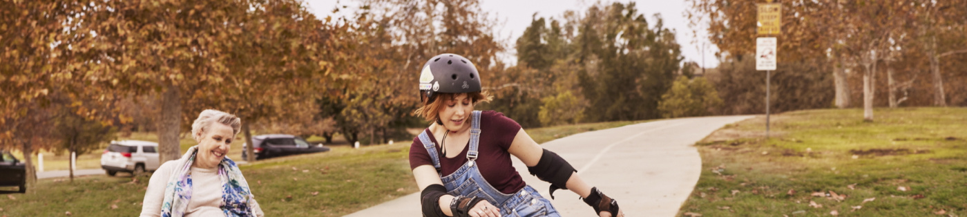 A woman in a wheelchair watching a woman roller skate 