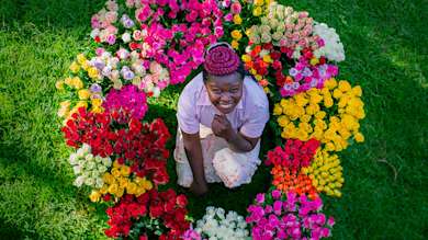 A woman sitting in a circle of flowers