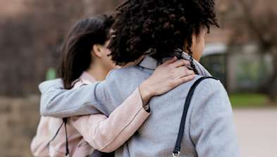 Two people with their arms round each other.