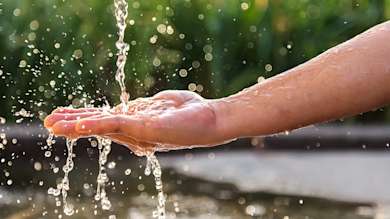 a person's hand under running water
