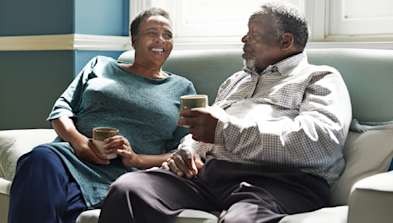 Two people sat chatting and having a coffee.