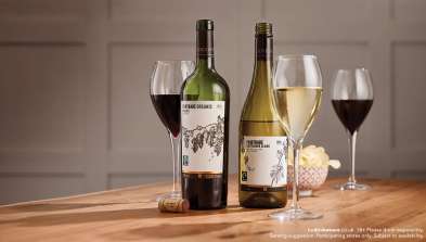 Bottles and glasses of wine on a wooden table.