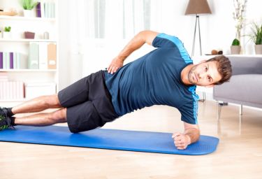 healthy-man-doing-side-plank-exercise-on-a-mat-picture-id509421844