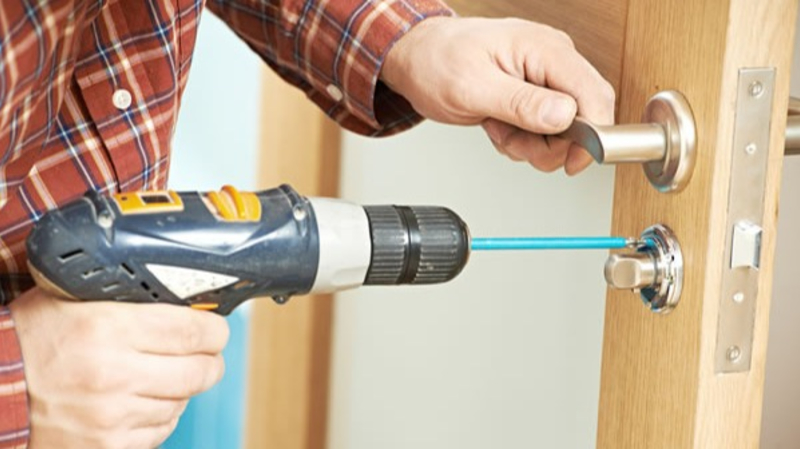 locksmith installing a new lock in a door