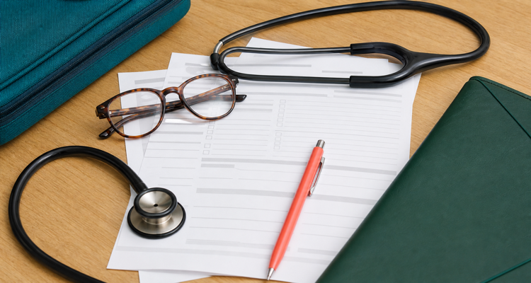 travel-insurance-documents-with-stethoscope-and-glasses-750x400