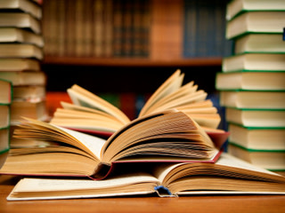 book open in front of book shelves