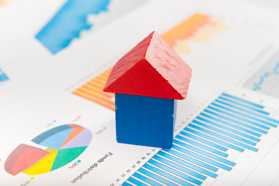Small wooden house on top of fund reports