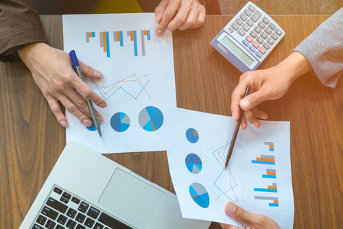 Two young businessmen studying financial charts.