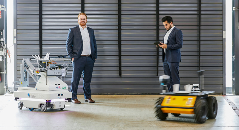 Max-Ferdinand Stroh und Murtaza Abbas testen am FIR an der RWTH Aachen, wie 5G den Einsatz von autonomen Transportfahrzeugen sicherer machen kann.