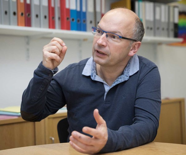 Der Schweizer Forscher Martin Röösli sitzt am Schreibtisch in seinem Büro und klärt im Interview darüber auf, wie Strahlung wirkt und wer Grenzwerte festlegt.