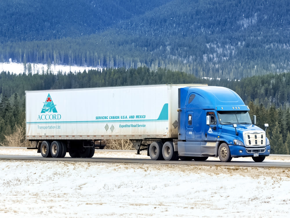 Camion d’Accord Transportation sur une route de montagne enneigée
