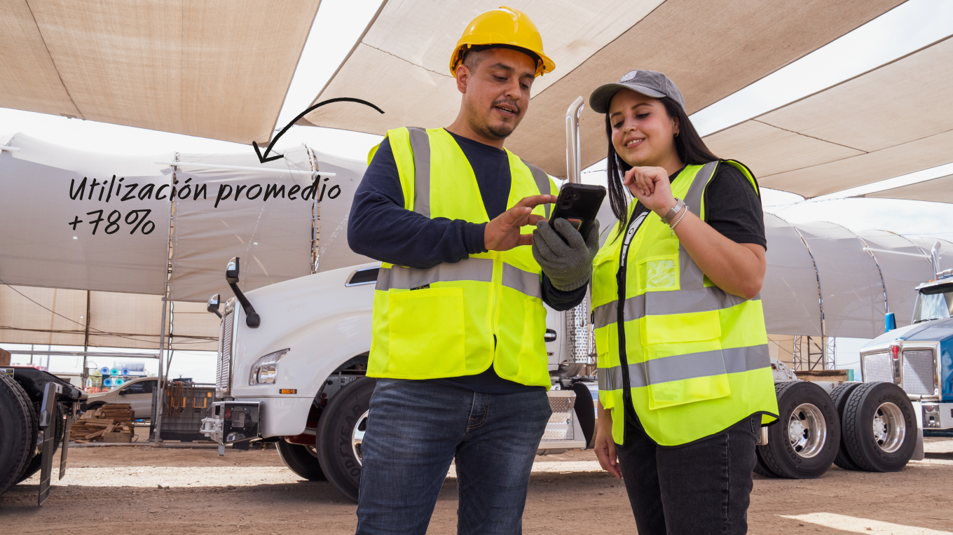 Dos trabajadores con chalecos amarillos revisan un celular en un patio de camiones. Texto: Utilización promedio +78%.