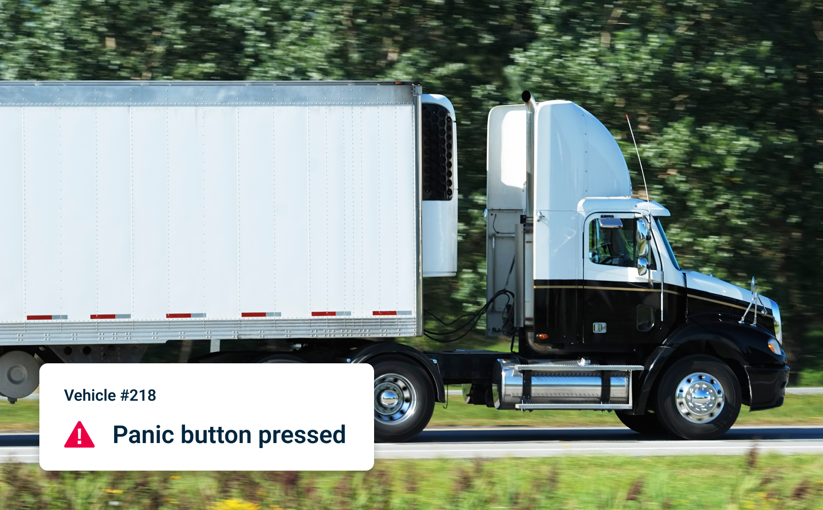 Semi-trailer truck parked on a road. Overlay shows intelligent alert of: Vehicle #218 Panic button pressed.