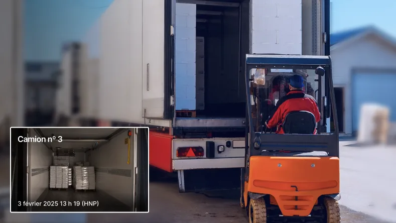 Un travailleur en train de charger un camion. À côté d’une caméra qui enregistre.