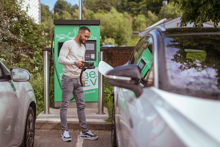 Man charging car at Be.EV rapid charger