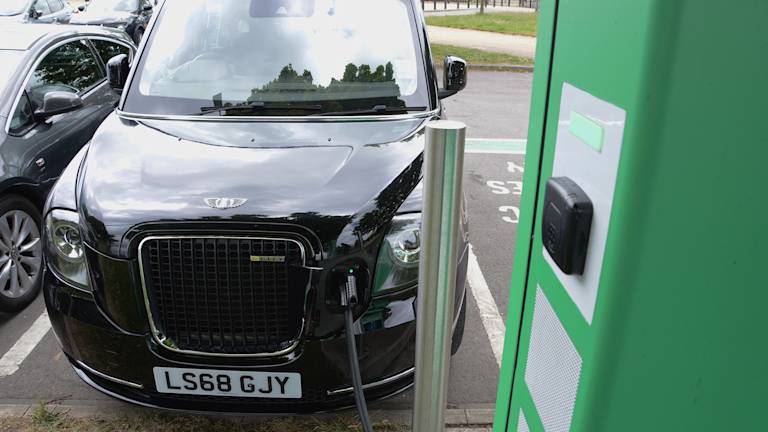 Black cab charging up at EV charging point