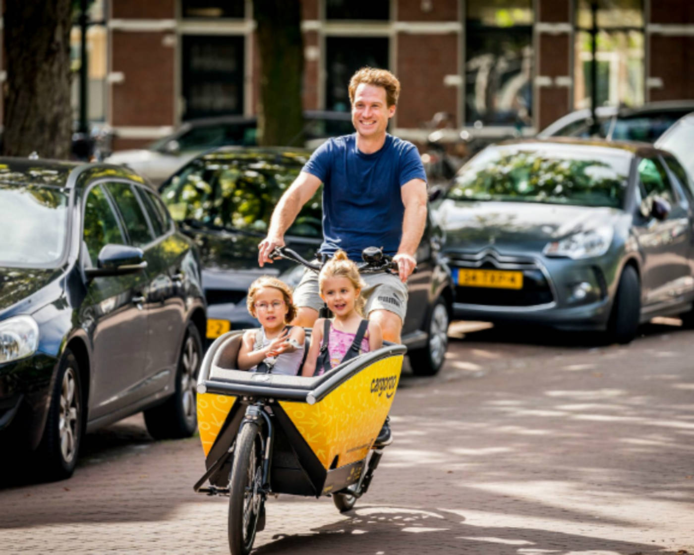 Cargoroo man and two children on eCargo bike on road