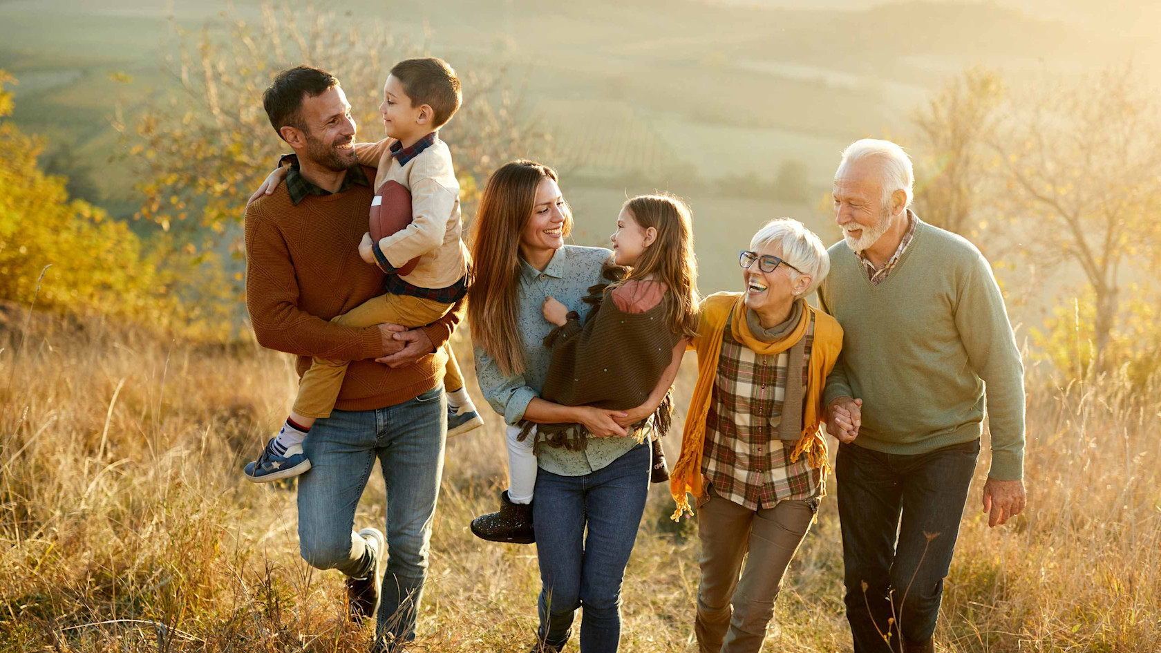 Families with three generations in an autumnal field