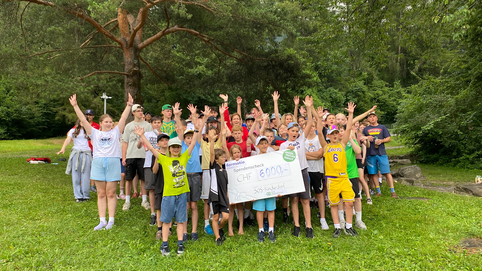 Children of the formatio public school cheering with the cheque for CHF 6000.