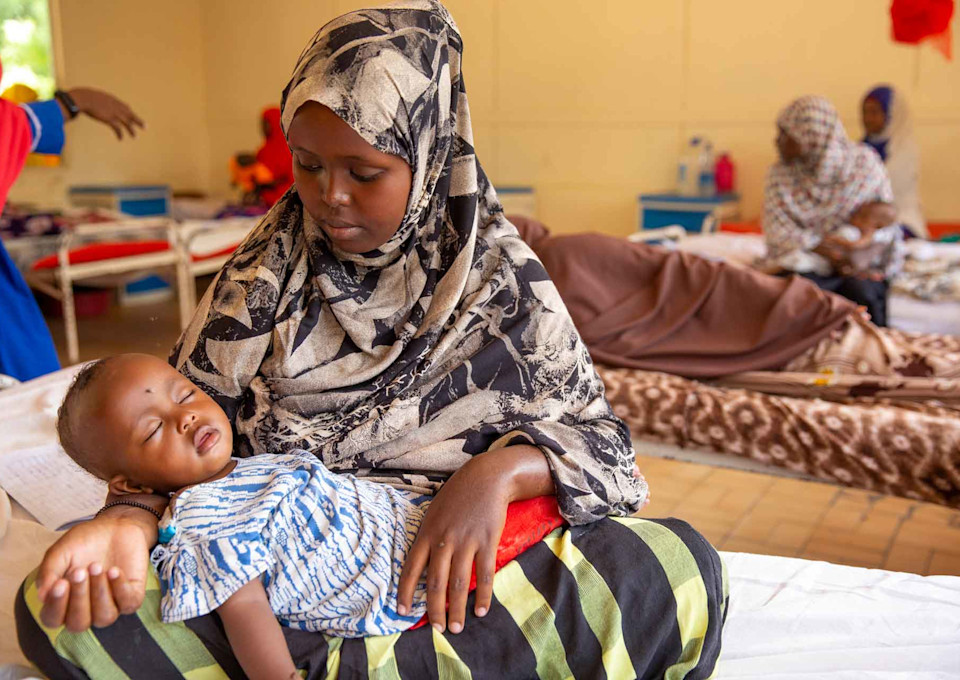 A young mother with her child in a hospital room in Mogadishu, Somalia
