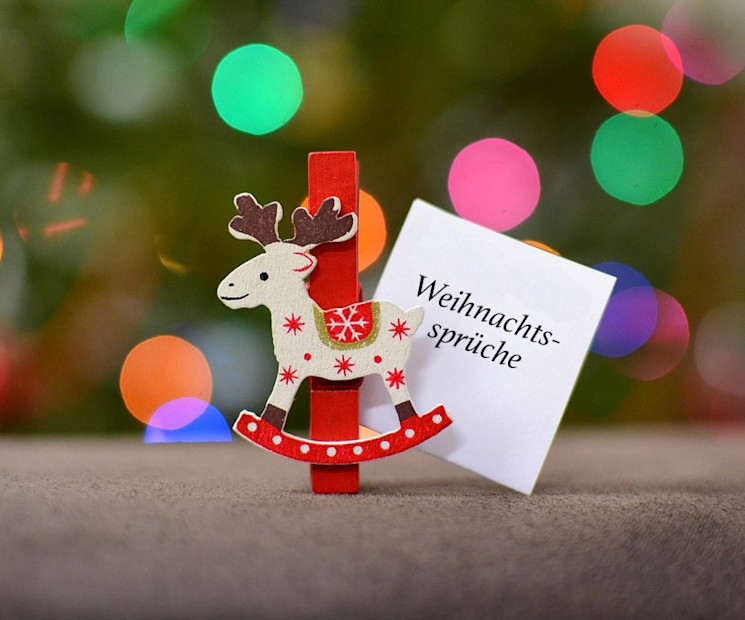 Weihnachtlicher Notizzettel mit Weihnachtsspruch und roter Rentierklammer für einen Weihnachtsgruß
