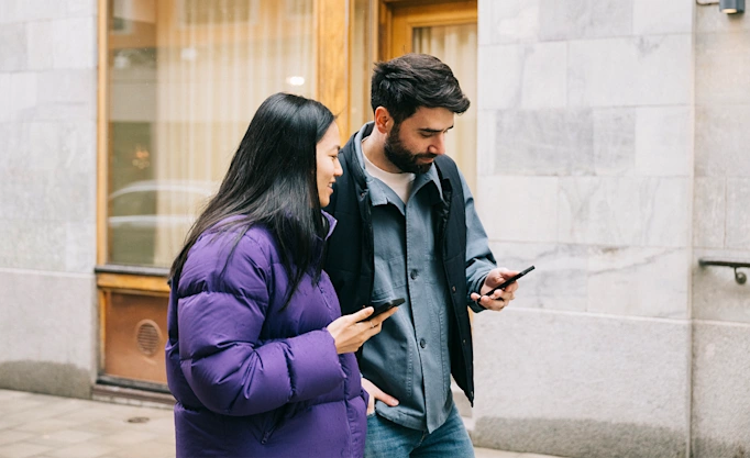 Two people looking at a mobile phone