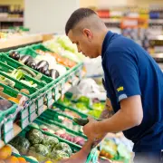 Volg Laden, Mitarbeiter räumt Gemüseregal ein