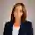 Janese Patterson with brown shoulder-length hair wearing a navy blazer and white top, smiling in a professional headshot.