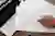 Person filling out tax forms including 1040 and W-4 with an orange pen next to laptop keyboard on wooden desk.