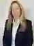 Professional portrait of Jennifer Pendzick with blonde hair wearing a navy blazer and white shirt, smiling against a neutral background.