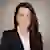 Heather Walker with long dark hair smiles in a professional headshot, wearing a navy blazer, white blouse, and pearl necklace.