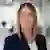 Jenny Anderson with blonde hair smiles in a professional headshot, wearing a navy blazer in a modern office setting.