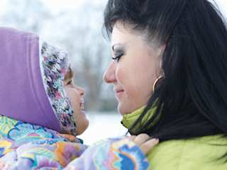 Mutter und Tochter schauen sich lächelnd in die Augen